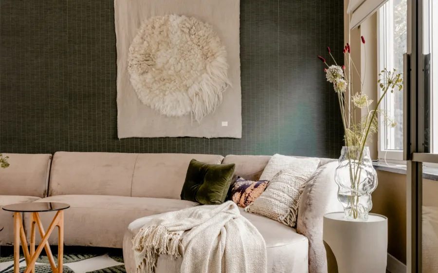 Woonkamer met stijlvolle accessoires zoals decoratieve kussens, vazen en abstracte kunst op de muur.