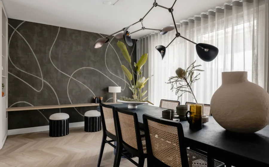 Stijlvolle woonaccessoires zoals vazen, decoratieve lamp en kamerplanten voor een gezellige woonkamer.