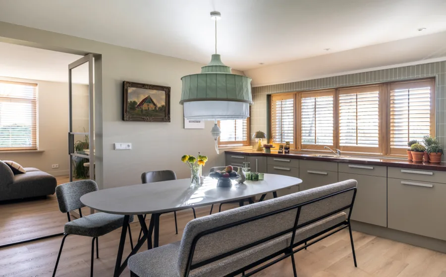 Gezellige keuken met horizontale jaloezieën voor brede ramen.