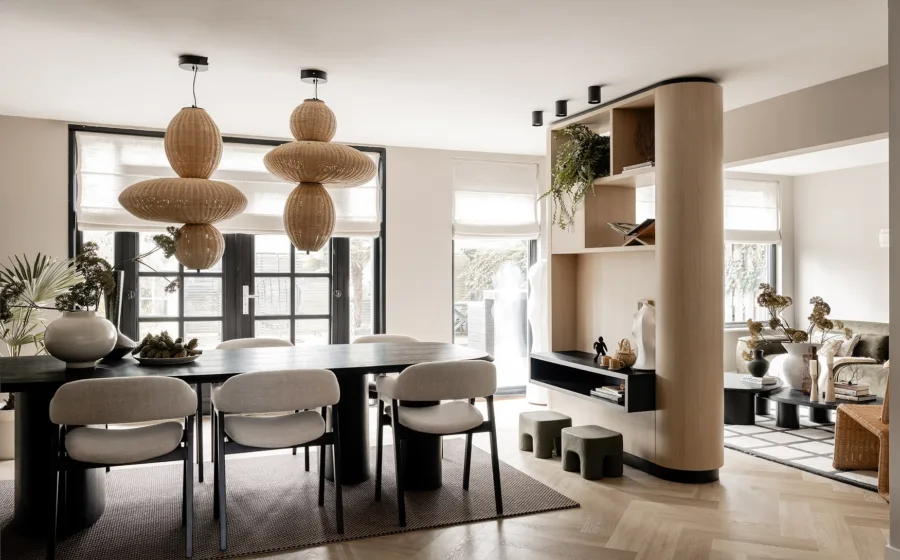 Warme woonkamer met grote ramen, houtlook vloer en vloerverwarming.