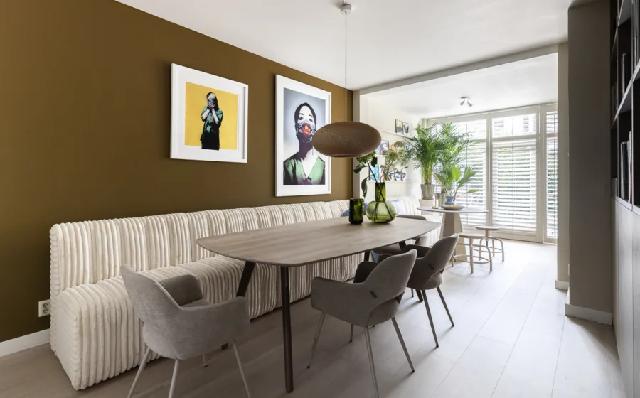 Keuken met ruime zithoek en witte shutters voor de tuindeuren.