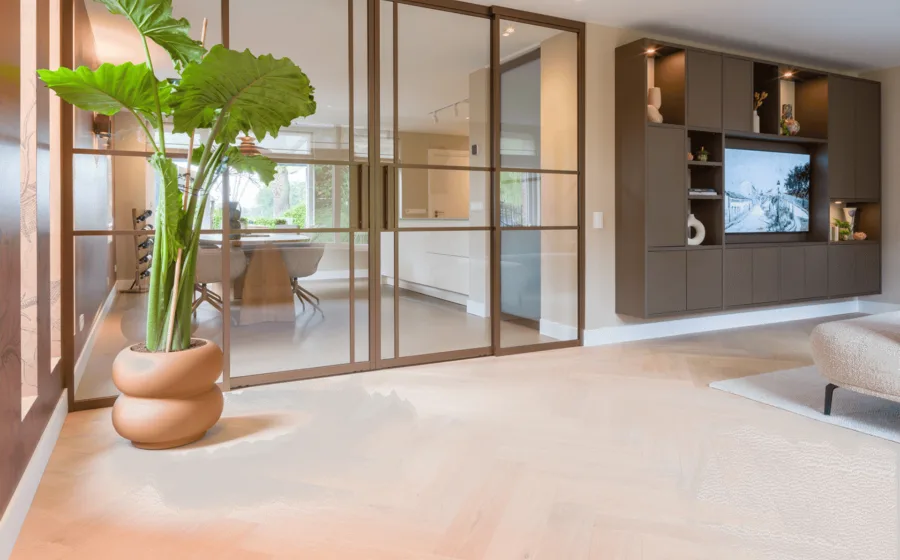 Lindura visgraat vloer in lichte hout tint met bronze stalen deuren en cinewall in de woonkamer