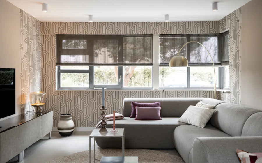 Retro interieur met behang met print en beige hoekbank in organische vormen