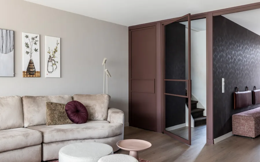 Hal met opvallend natuurmotief behang in donkere kleuren en stalen deuren.