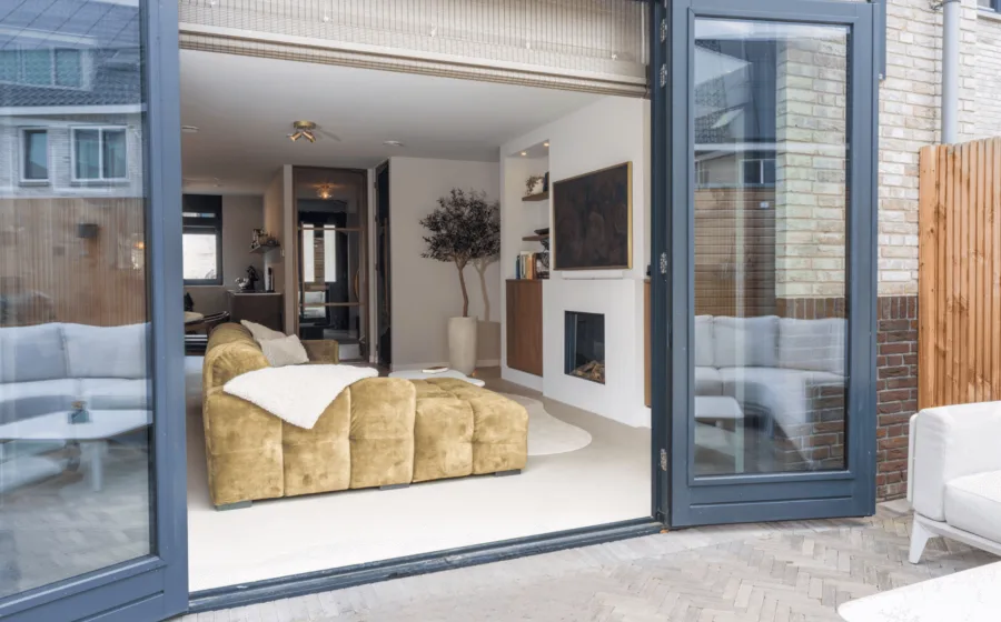 Warm kleurrijke interieur met licht grijze gietvloer, kasten op maat en bronzen stalen deuren