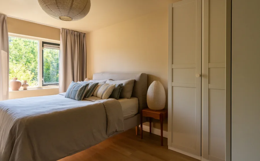 pvc-vloer licht eiken lange plank en beige bruine overgordijnen in slaapkamer