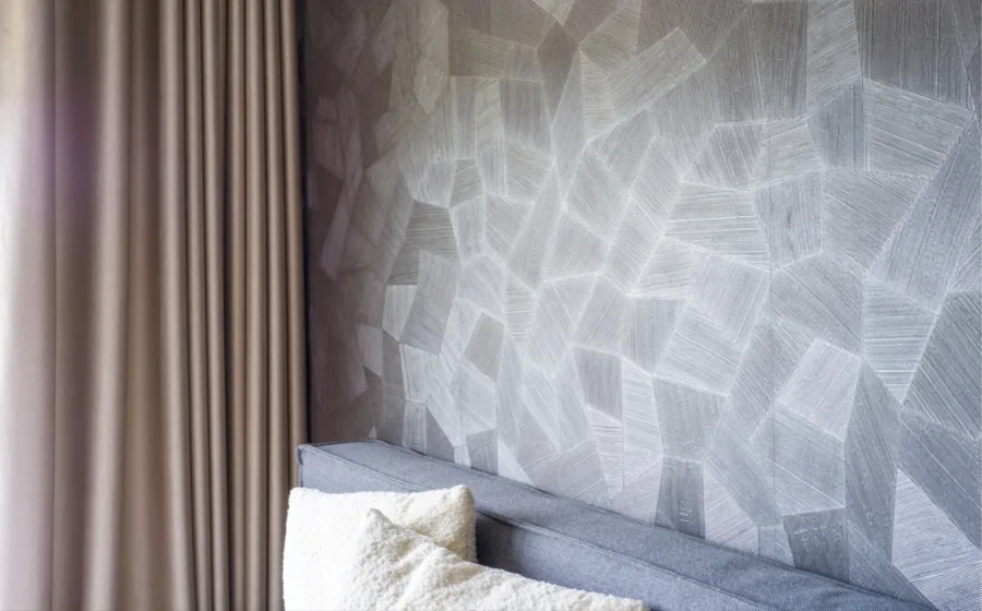 Grijs arte behang achter bed met bruine overgordijnen