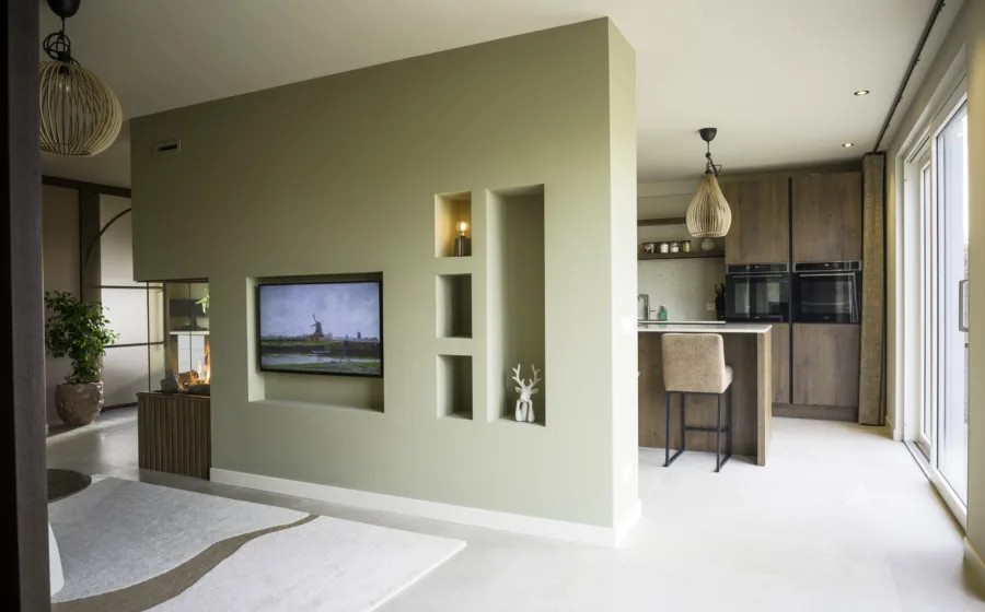 Woonkamer en keuken gescheiden door roomdivider met elektrische haard
