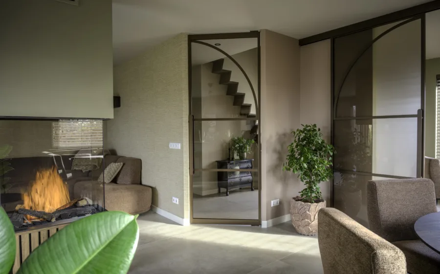 Woonkamer met lichtgrijze keramische tegels vloer en bronzen stalen deuren