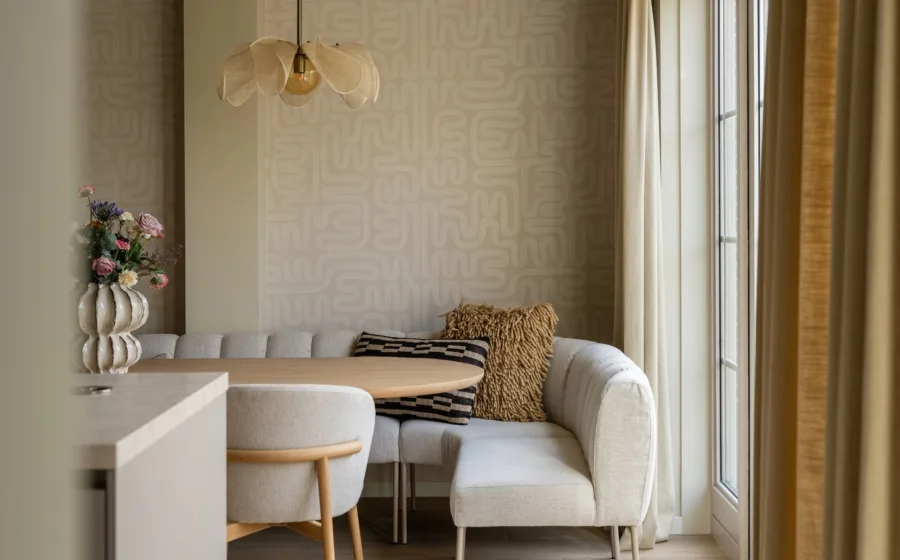 Moderne eethoek met houten tafel en comfortabele stoelen, gefilterd licht door elegante Loft79-gordijnen Schelp 05; een warme en uitnodigende ruimte voor gezin en gasten..