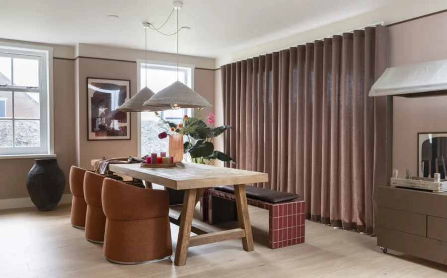 Gezellige eetkamer met bankje, robuuste houten tafel en zachte overgordijnen