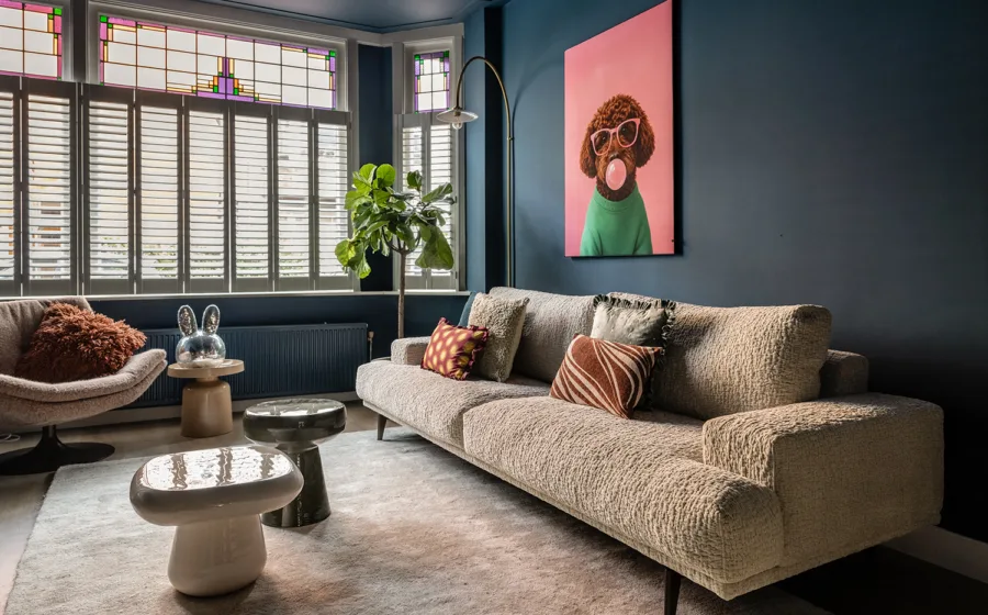 Warme eclectische woonkamer met kleurrijke kunst en natuurlijke materialen.