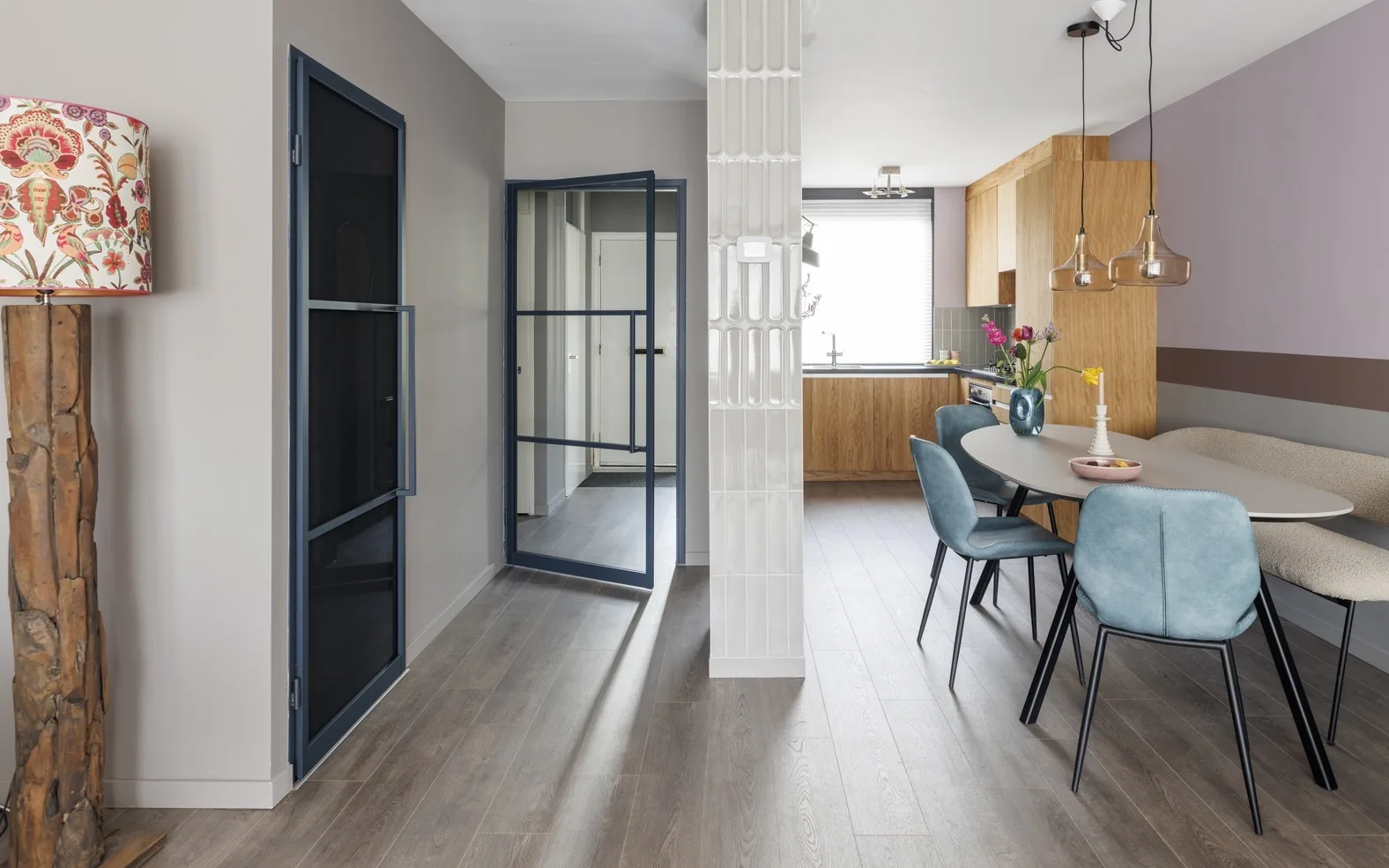 Gezellige keuken met een donkere laminaatvloer en een grote eettafel.