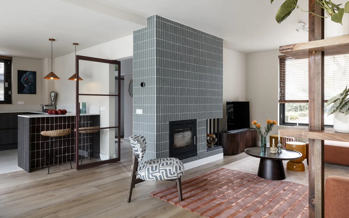 Warme houten details van vloeren, meubels en jaloezieën die samenhang en sfeer creëren.