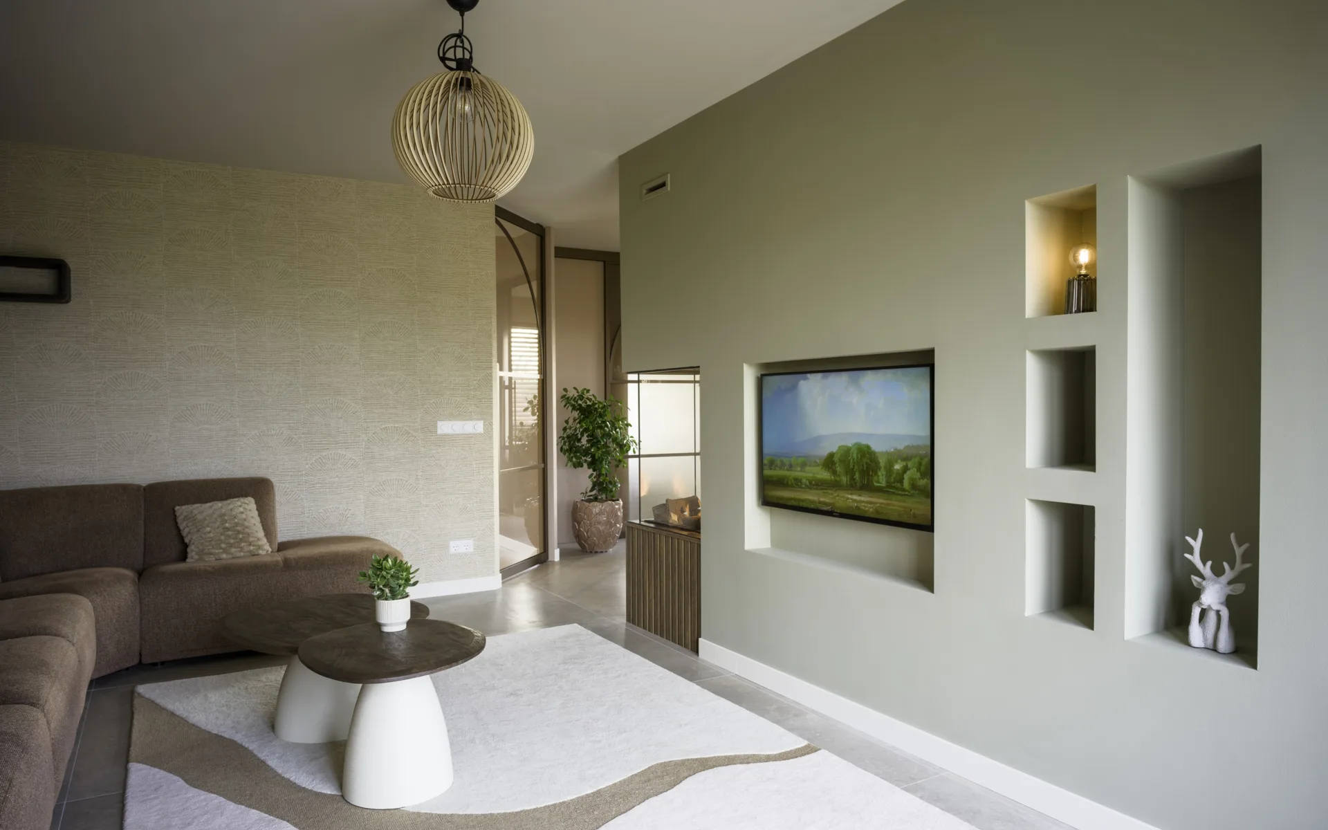 Woonkamer met hoekbank, zacht vloerkleed en behang met subtiel patroon