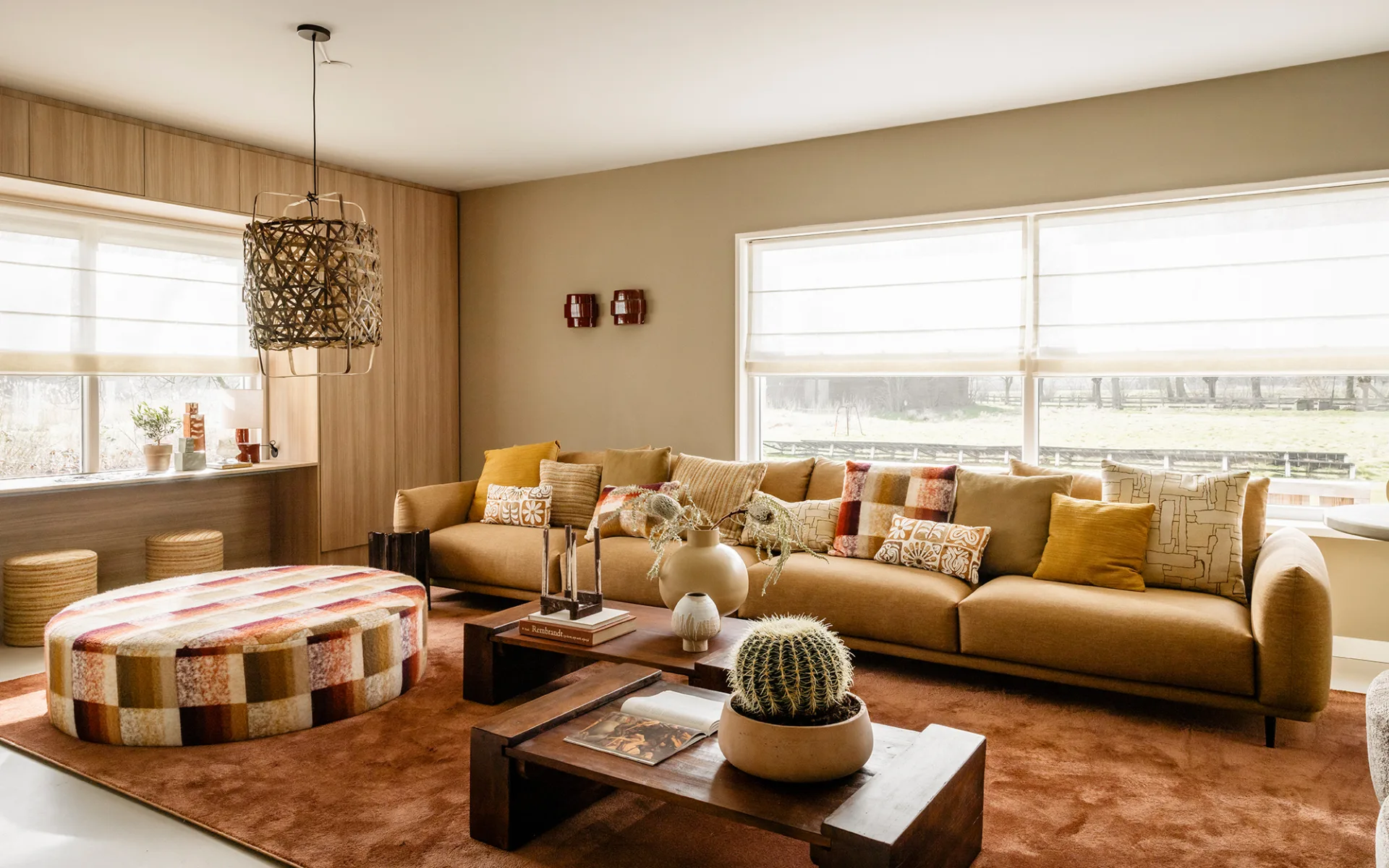 Sfeervolle woonkamer in vrijstaande boerderij met warme marmoleum vloer en elektrisch bedienbare vouwgordijnen.