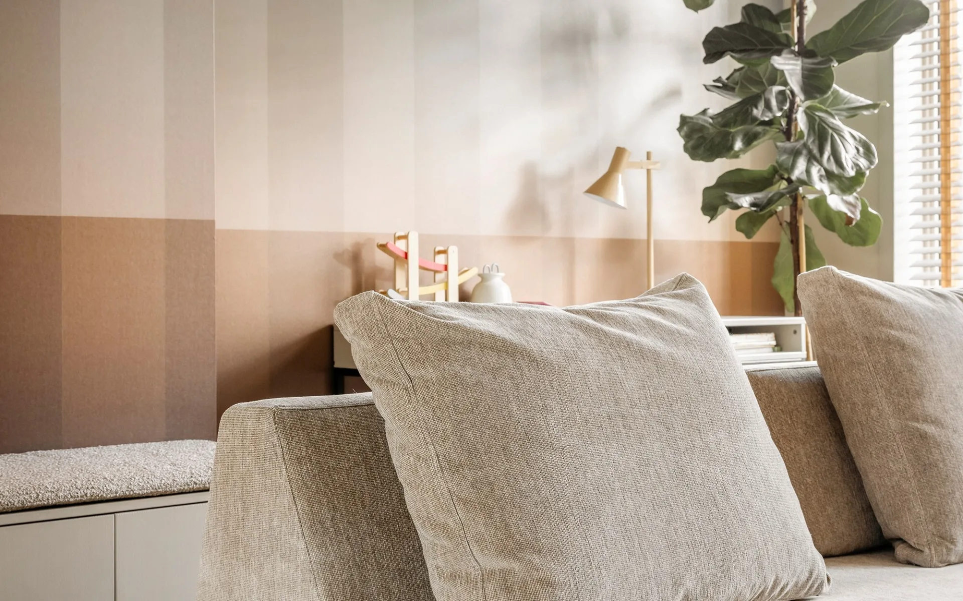 Woonkamer met grijze bank en streep behang
