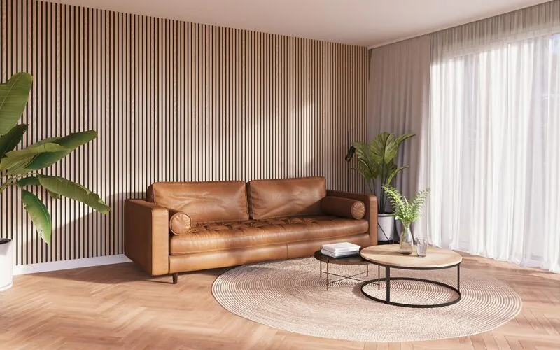 Woonkamer met bruine bank en houten lattenwand op de achtergrond