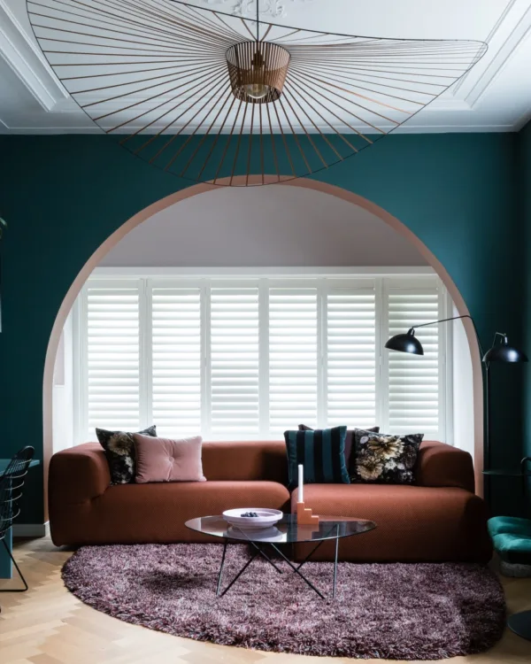 Hotel chique interieur met luxe bankstel en witte shutters als raamdecoratie.