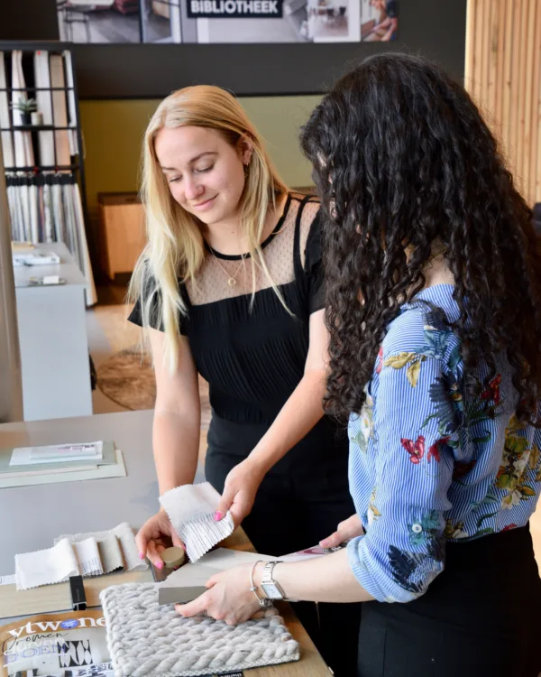 twee mensen kijken naar een moodboard voor interieuradvies en naar verschillende stalen van producten