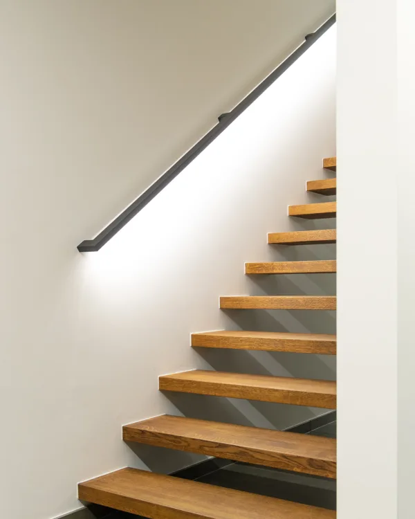 Detail trap met led trapleuning waarbij het licht naar beneden op de treden schijnt