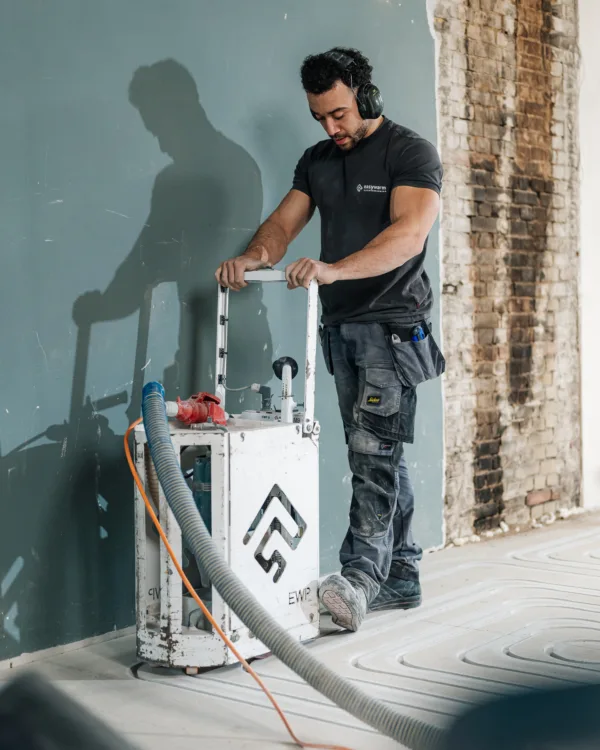 Vloerverwarming monteur bezig met infrezen van sleuven