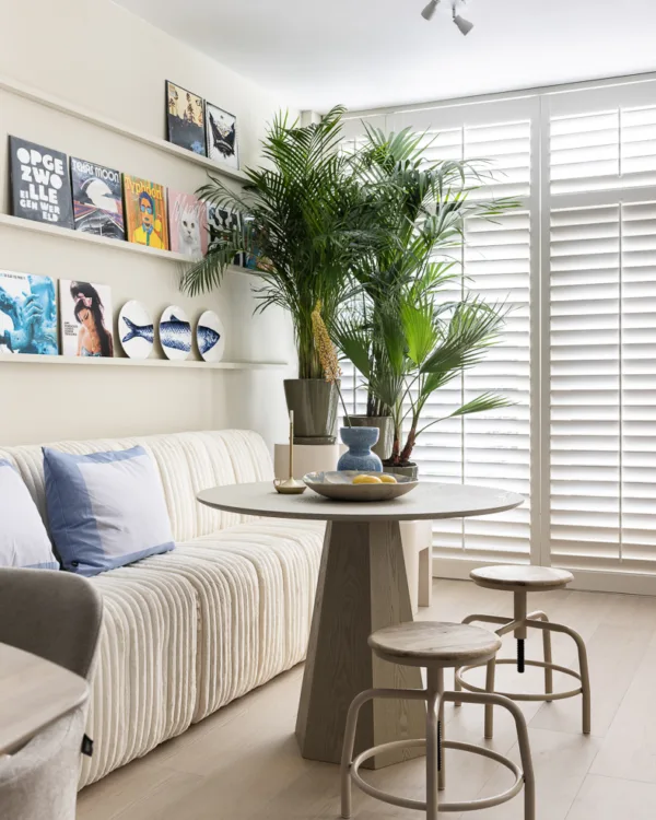 Woonkamer in Basic naturel kleuren met witte shutters.