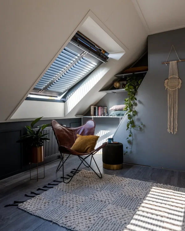 Zwarte shutters in een dakraam op een zolderkamer.