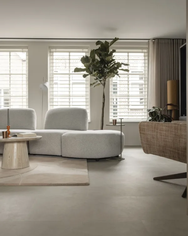 Scandinavisch huis met lichtgrijze betonlook vloer, zwarte kast op maat en moderne bank