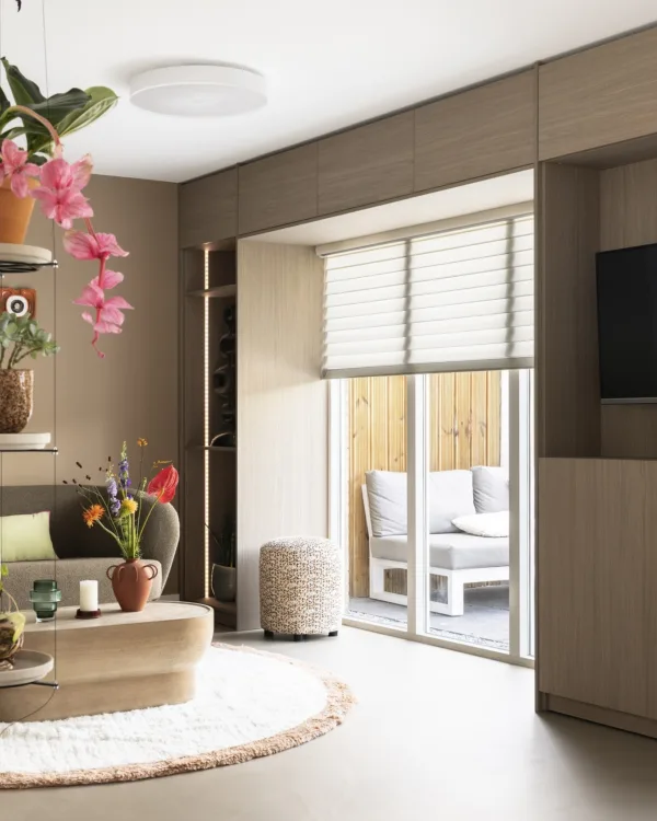 Woonkamer met zandkleurige betonlook vloer en beige bank