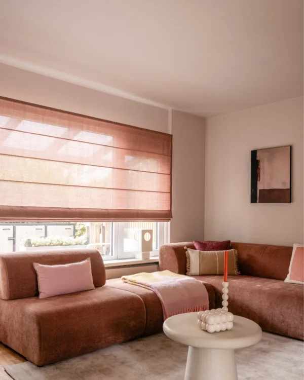 Warm kleurrijk interieur met oude roze vouwgordijnen in woonkamer met roze bank