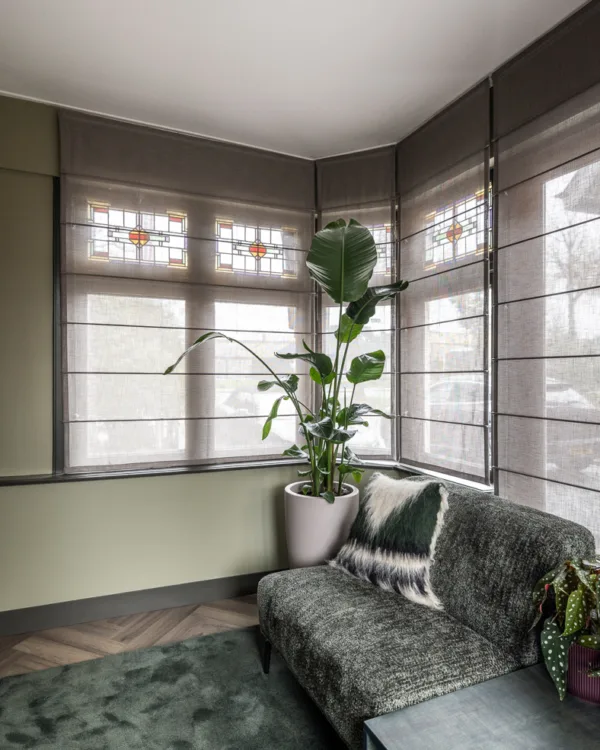 Elegante vouwgordijnen die naadloos passen in alle ramen en hoeken, met zachte kleuren en luxe materialen die warmte, sfeer en huiselijkheid toevoegen aan het monumentale interieur.