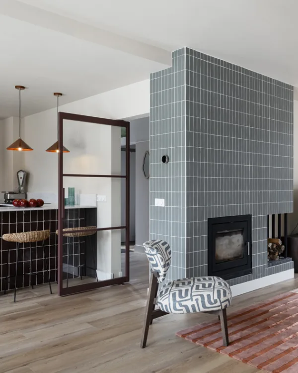 Warme houten details van vloeren, meubels en jaloezieën die samenhang en sfeer creëren.