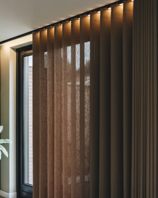 Elektrisch bedienbare gordijnen in warme bruintint voor schuifpui