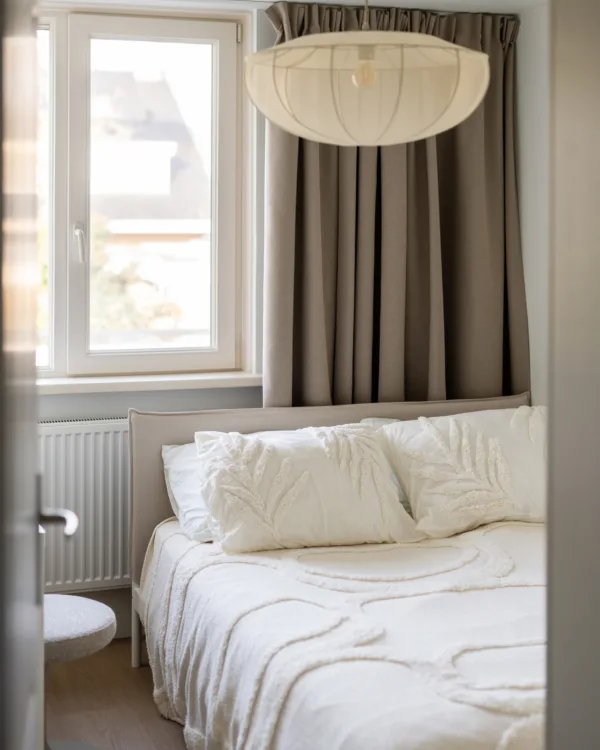 Knusse slaapkamer met overgordijnen van Aanhuis.nl en serene, neutrale kleuren voor rust en comfort.