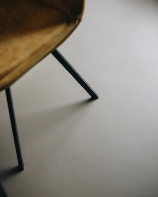 Sfeerfoto grijze gietvloer met cognac kleurige stoel