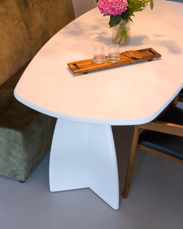 Grijze gietvloer met moderne witte eettafel en groene meubels