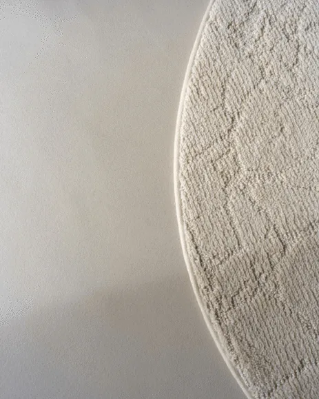 Licht grijze gietvloer met organische, creme vloerkleed