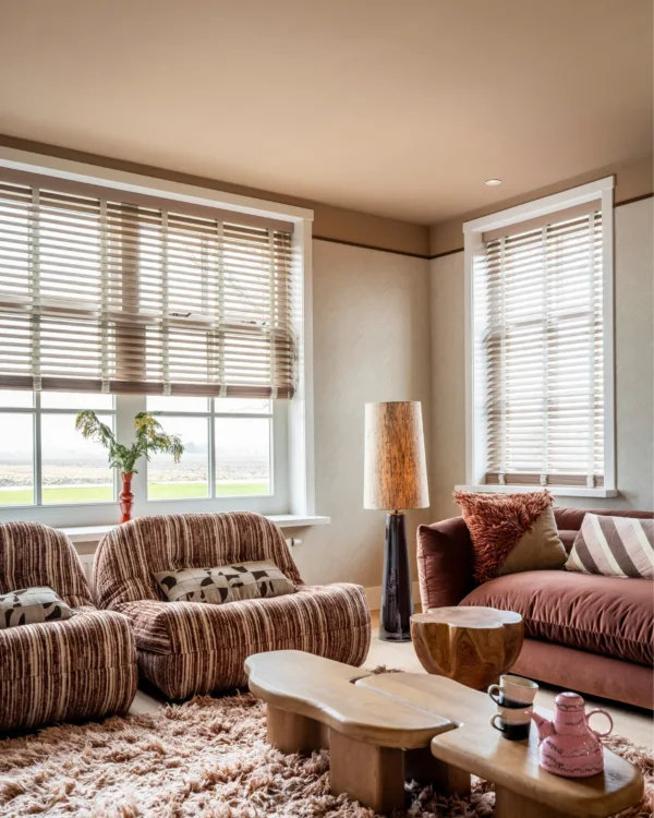 Warmkleurijke woonkamer met fluffy vloerkleed en houten jaloezieën