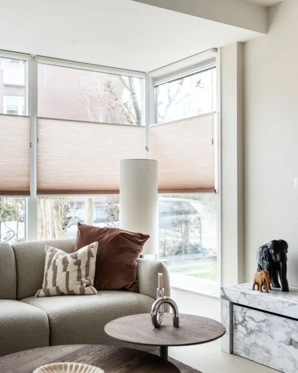 woonkamer met dupli-gordijnen in roze tint en licht geverfde muren