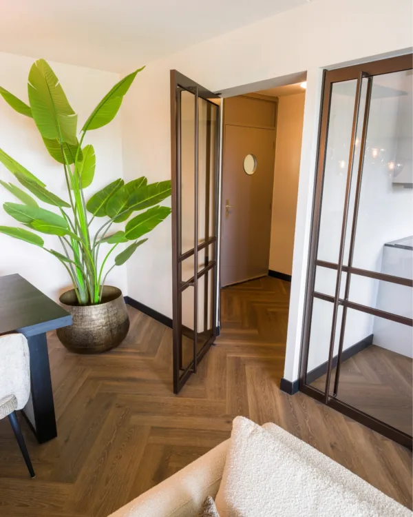 Bronze stalen deuren naar hal en donkere eiken visgraatvloer