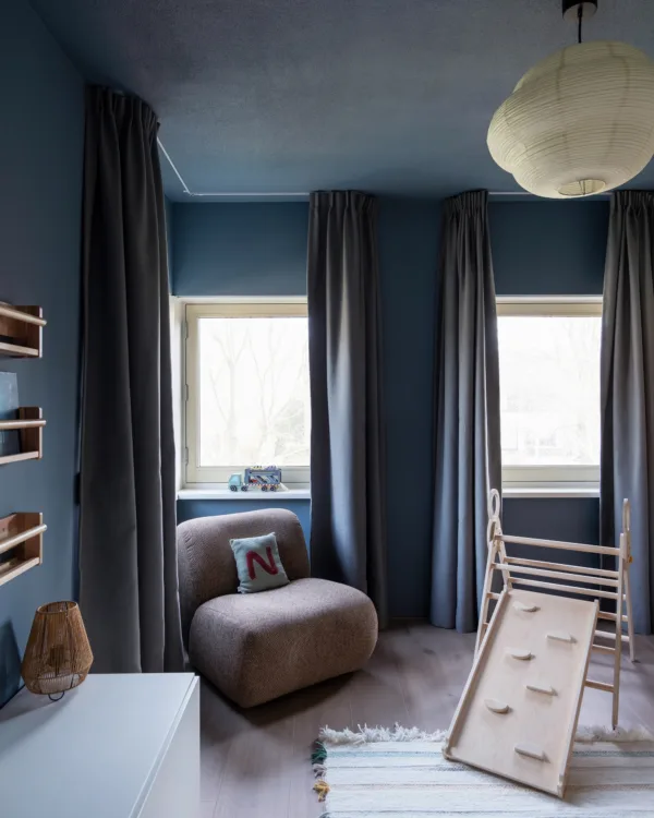 Speelse jongenskamer met blauwe accenten, Loft79 overgordijnen in Wilg 24 en laminaatvloer van Aanhuis.nl; ruimte voor spelen, leren en slapen.
