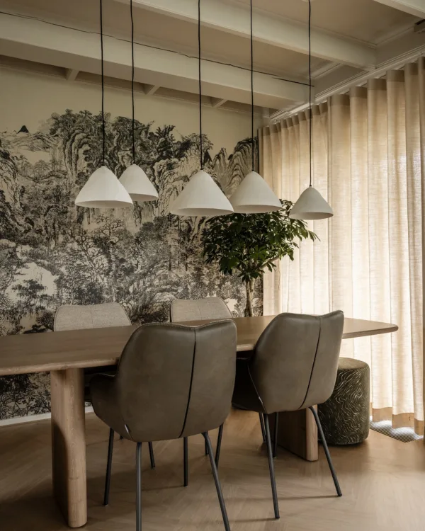 Lichte eethoek met bijzonder behang en stijlvolle wavegordijnen voor een gezellige sfeer.