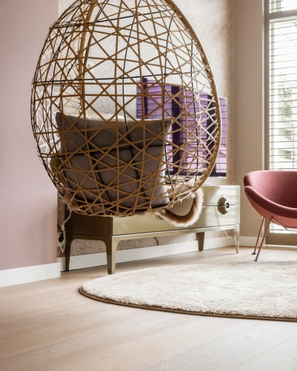 Warm kleurrijke woonkamer met lichte houtlook pvc-vloer en beige vloerkleed