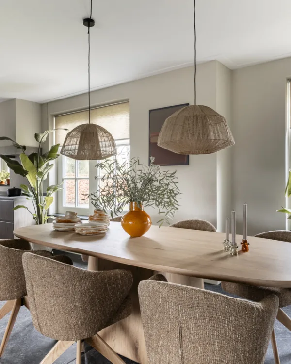 Landelijke eetkamer met robuuste eettafel, lichte kleuren en praktische tegelvloer.