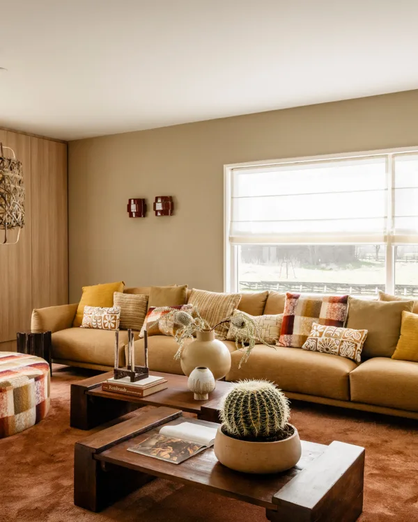 Sfeervolle woonkamer in vrijstaande boerderij met warme marmoleum vloer en elektrisch bedienbare vouwgordijnen.