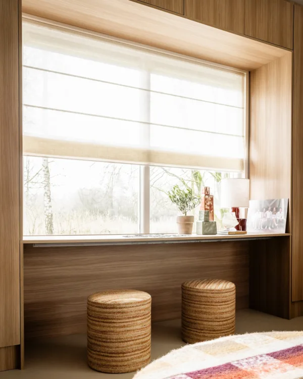 Open leefruimte met harmonieuze mix van Scandinavisch en werelds interieur Raamdecoratie met vouwgordijnen die zorgen voor zacht licht en een warme uitstraling.