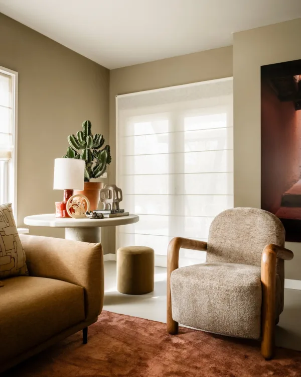 Woonkamer met luxe vouwgordijnen en warme, natuurlijke materialen voor een knusse sfeer.