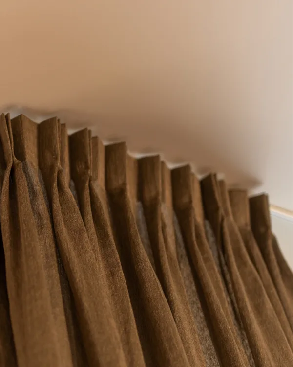 Close-up bruine gordijnen met vlinderplooi