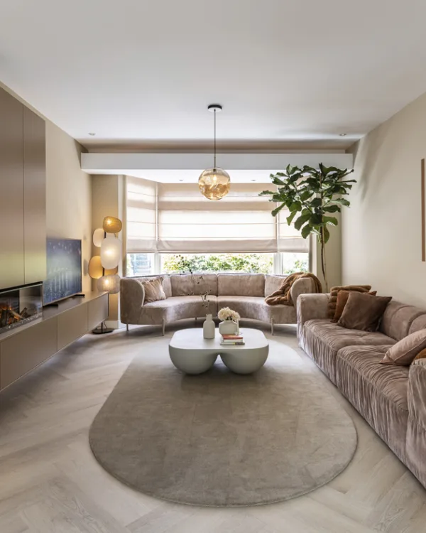 Woonkamer met visgraat pvc vloer, kast op maat met elektrische haard en beige bank